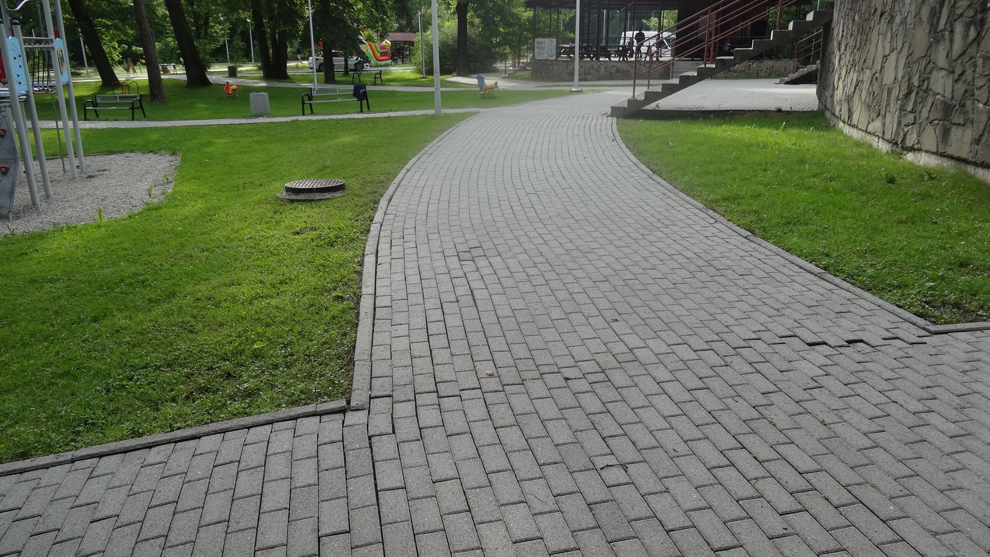 Umyta alejka z kostki brukowej prowadząca przez park w Beskidach