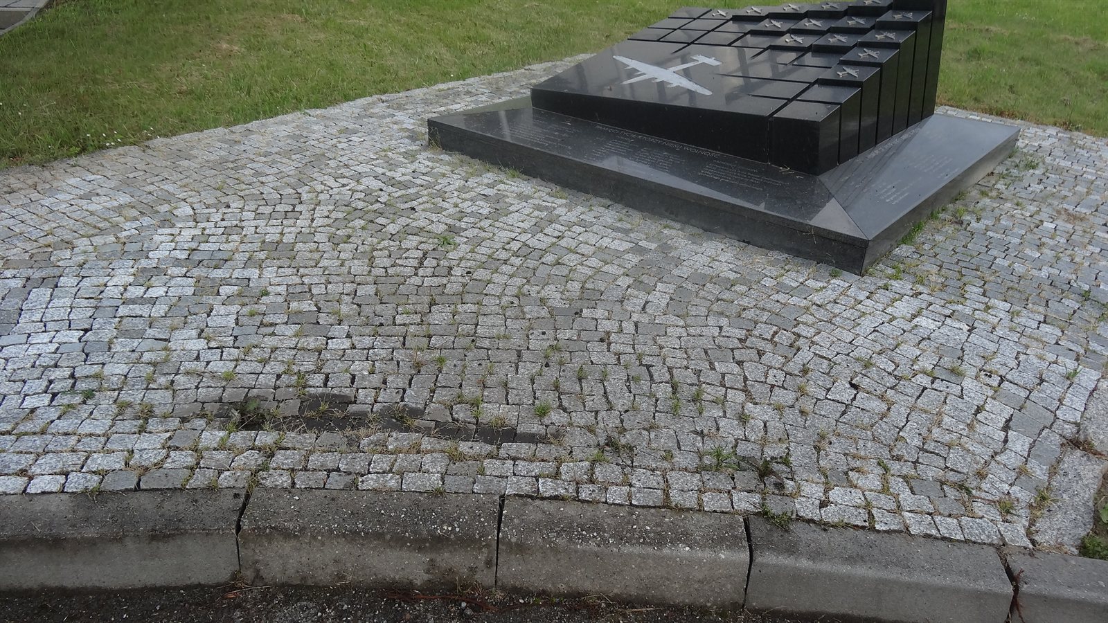 Plac z kostki granitowej z chwastami i mchem w spoinach, stan przed czyszczeniem