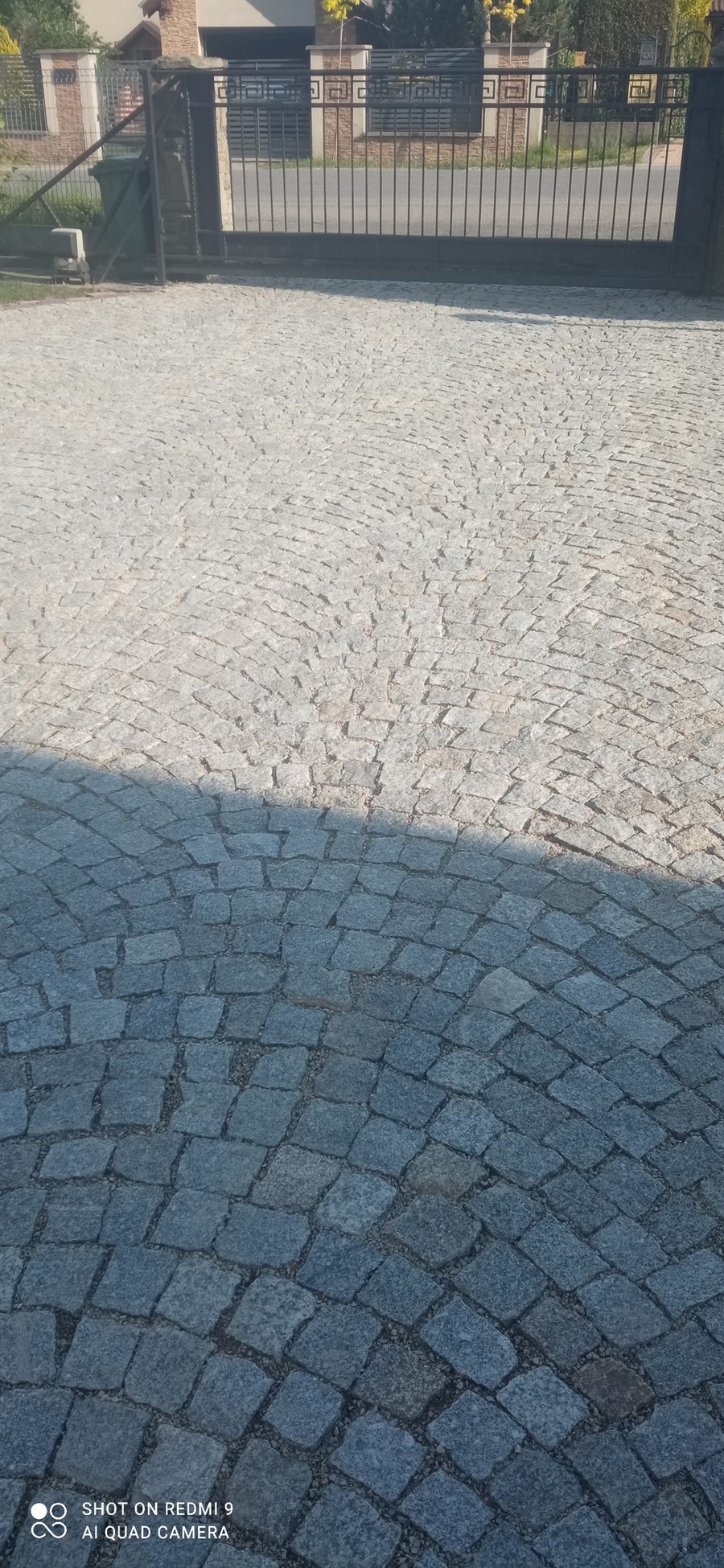 Podjazd z kostki przed czyszczeniem, widoczne ciemniejsze plamy na powierzchni